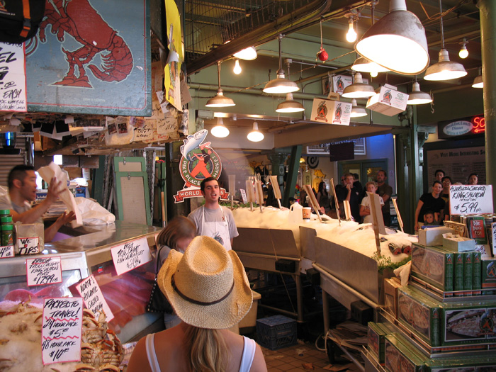 We and other tourists watch the famous fish throwing at Pike's market in Seattle