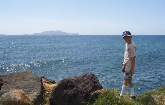 Gaetan posing by the rocks in Trois Riviers with Les Saintes in the background