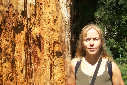 Lillemor standing by a tree along the trail